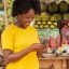 Market Vendor accessing the MTN MoMo Loans and Savings on her phone -- Enugu Ezike traders deserve the same